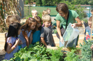 Mrs. Horst adds compost to the garden