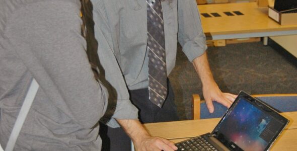 Charlie Reisinger instructs a student on their new laptop