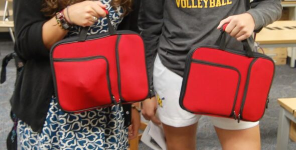 Students carry their new laptops