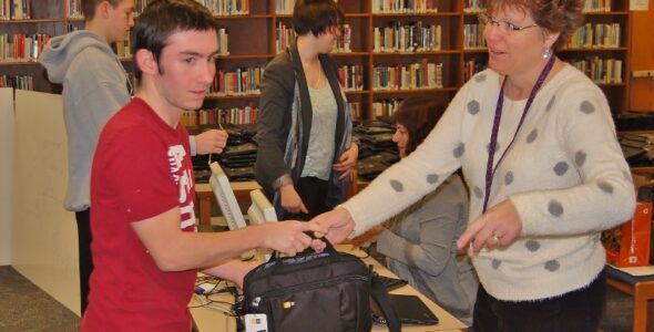 Sophomore Daniel Bleacher gets his new laptop from district technology analyst Shelby Foster.