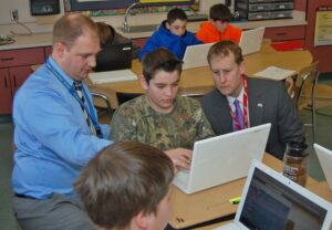 Teacher Kevin Bower, left, and state Rep. Ryan Aument, right, watch Masyn Jones demonstrate MySciLife.