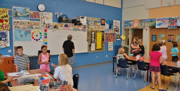 Parents and students check out the art room, which is illuminated primarily by natural light.