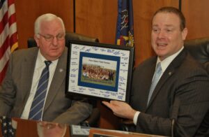 Commissioners Dennis Stuckey, left, and Scott Martin accept a signed photo of the state champs.