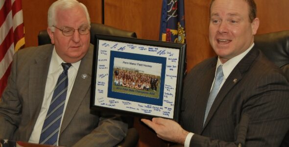 Commissioners Dennis Stuckey, left, and Scott Martin accept a signed photo of the state champs.