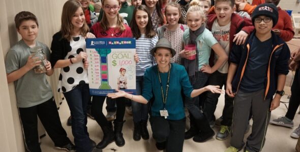 Lorien Gilbert with her students while wearing a hat