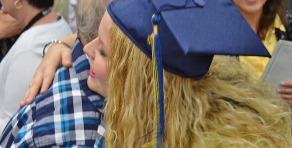 Graduate hugs family member