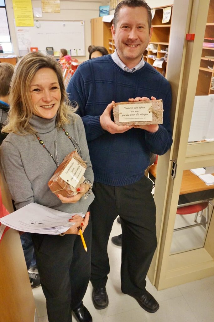 Teachers Beth Martin and Jason Ayers hold their Hambright bricks