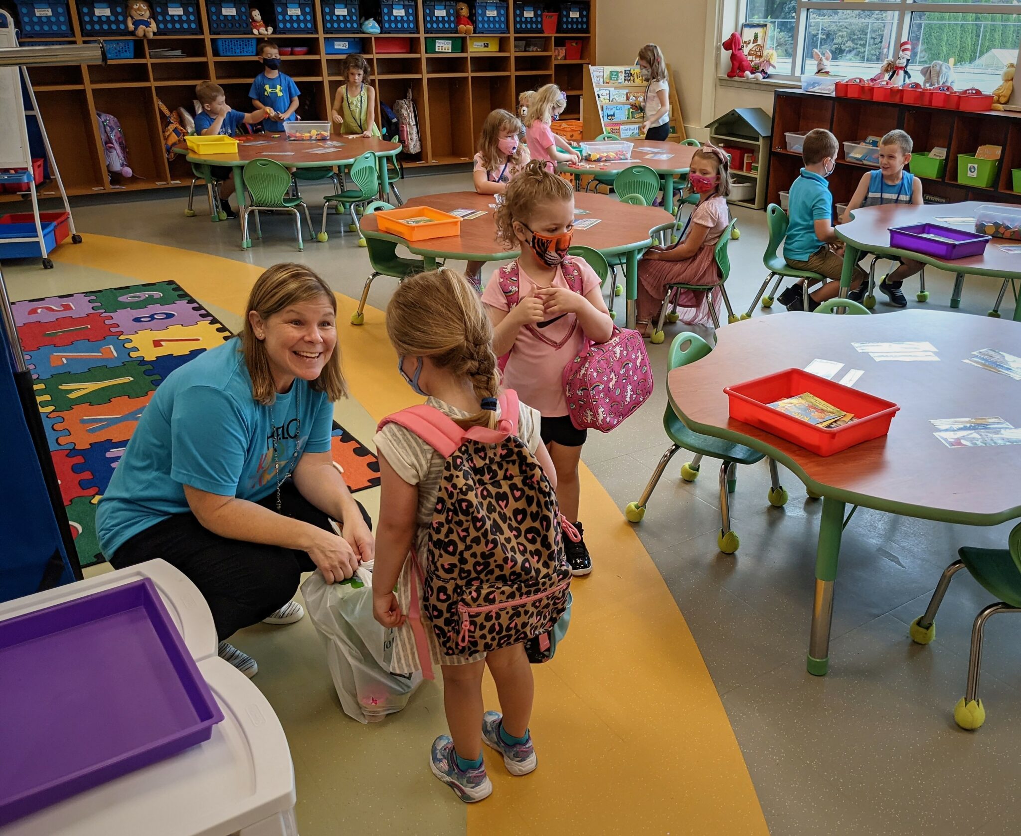 A teacher greets a student at Conestoga Elementary