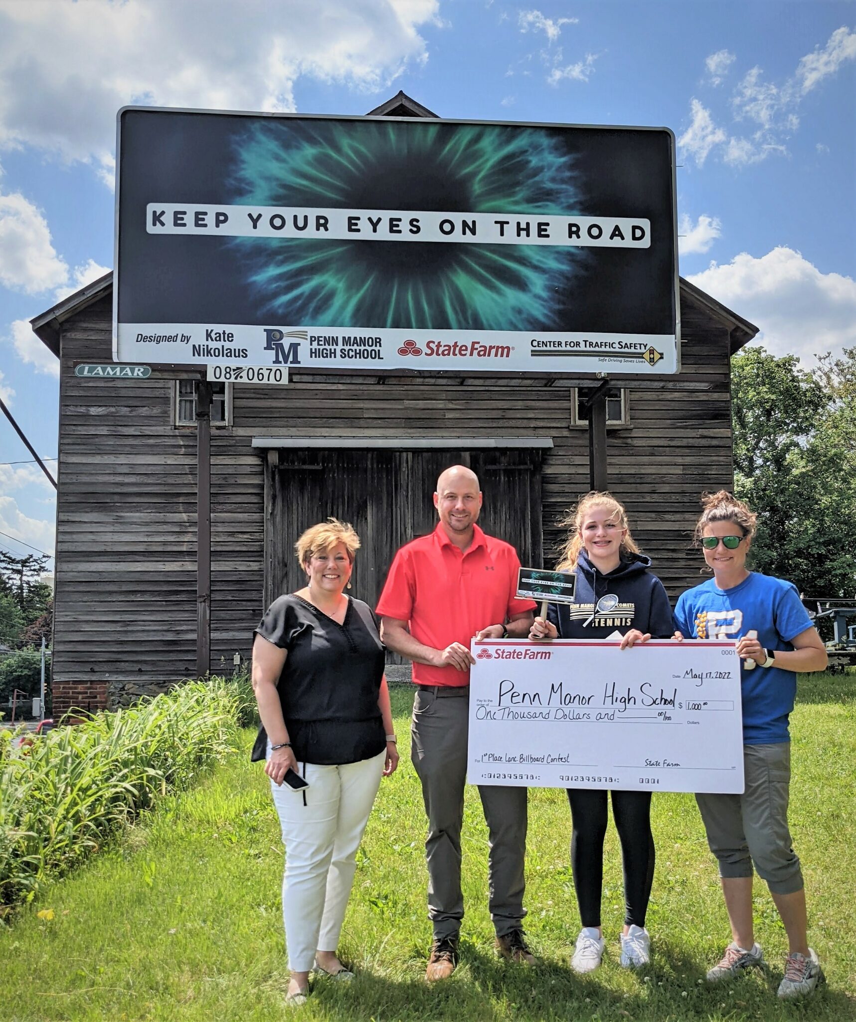 Photo of student, teacher and officials at billboard unveiling