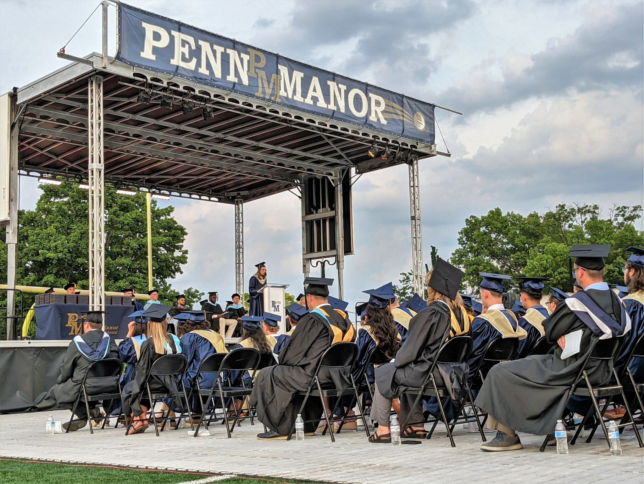 Photo of a student speaker addressing graduates.