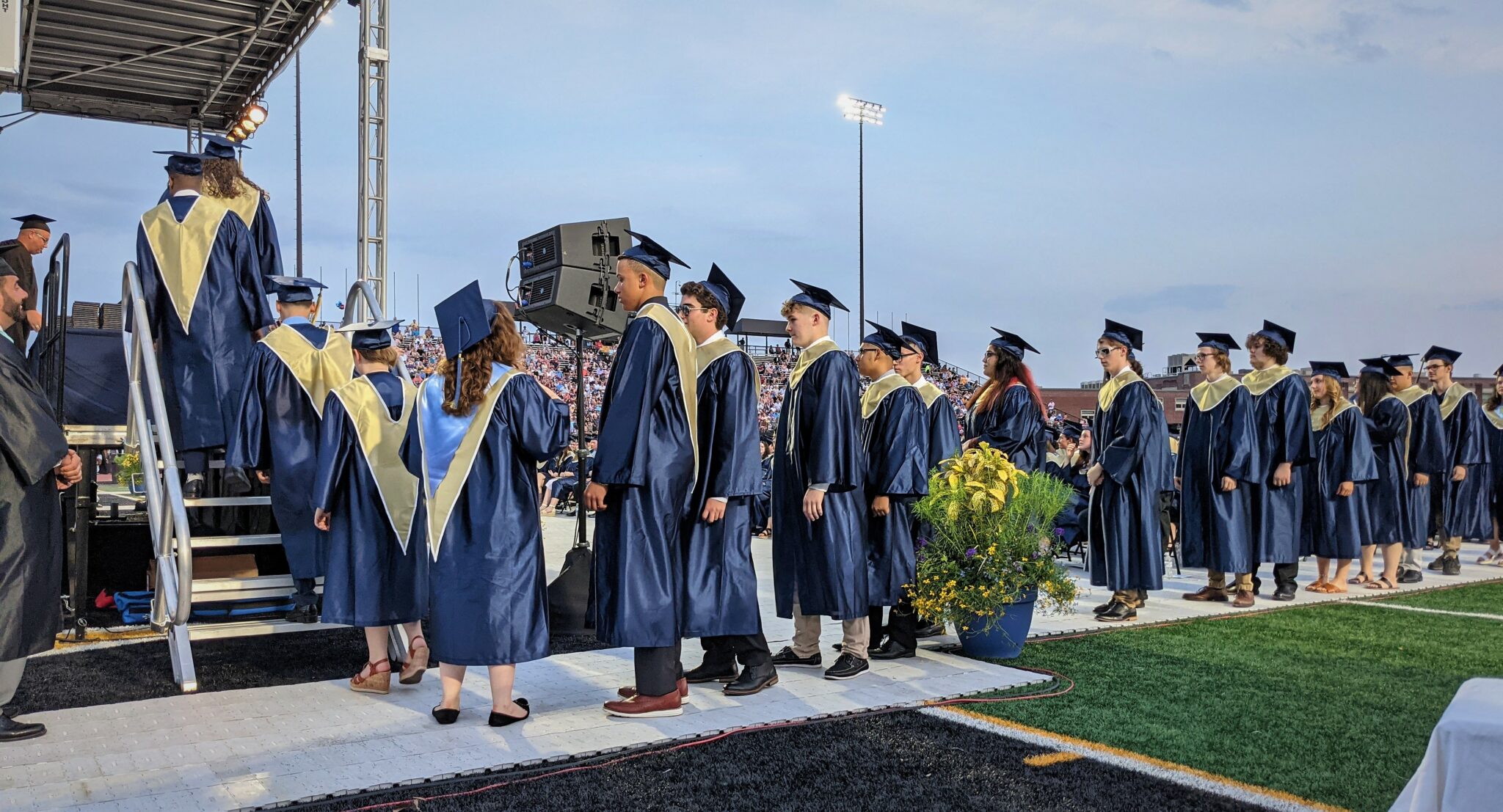 Photo of graduates lining up to receive diplomas