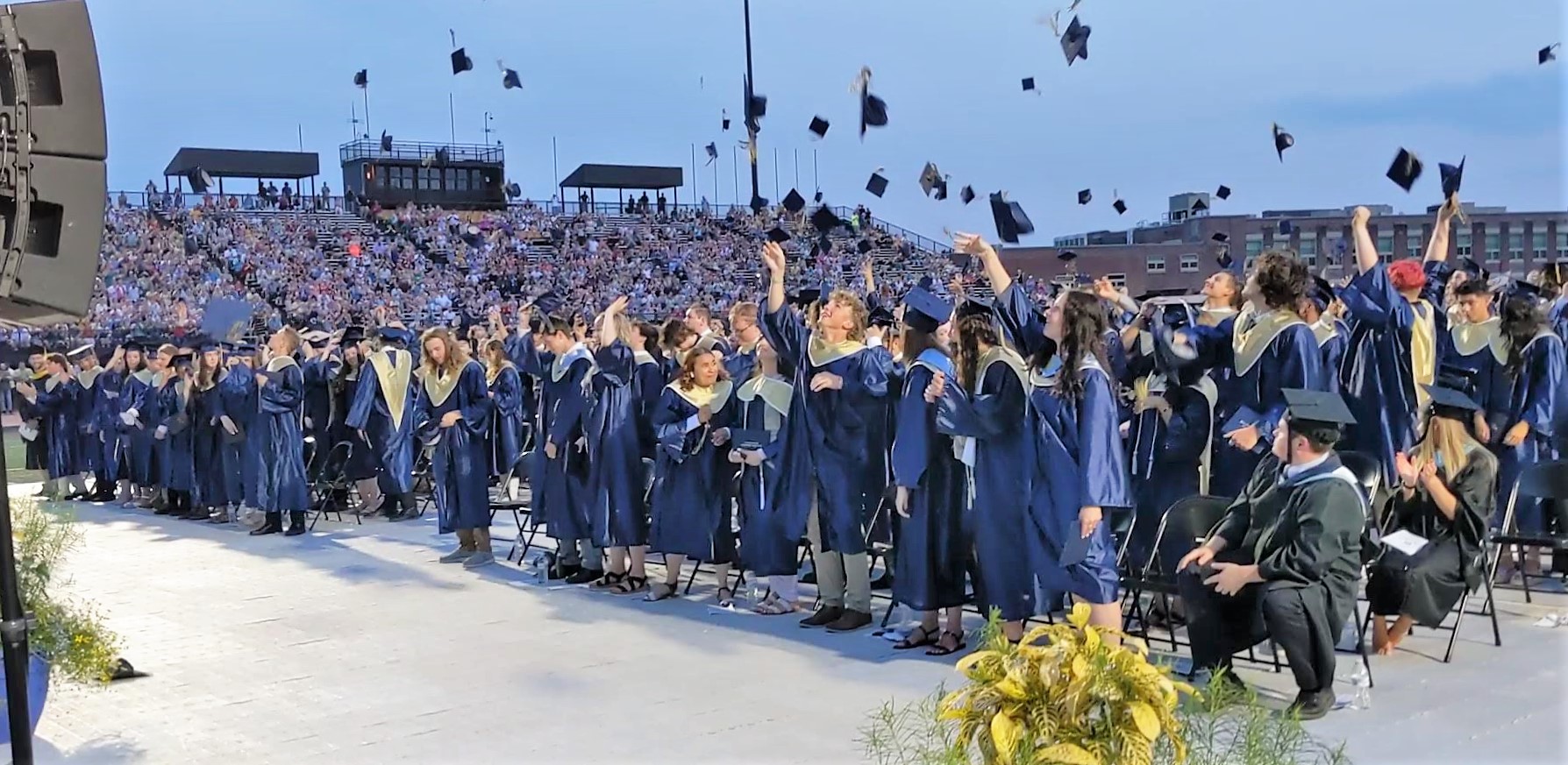 Photo of graduates tossing caps.