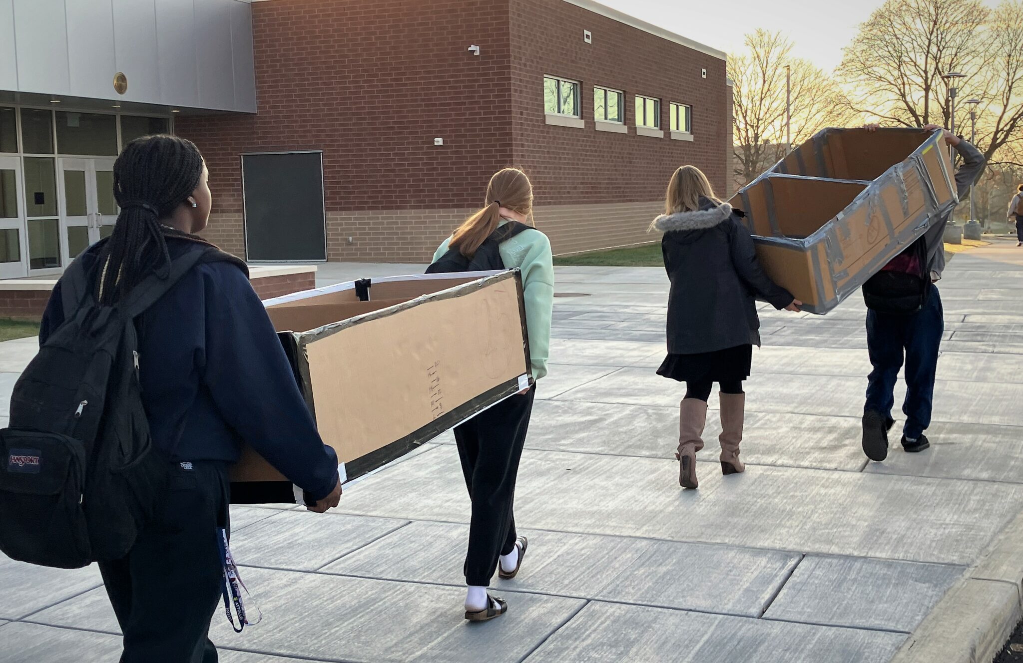 Photo of students carrying boats