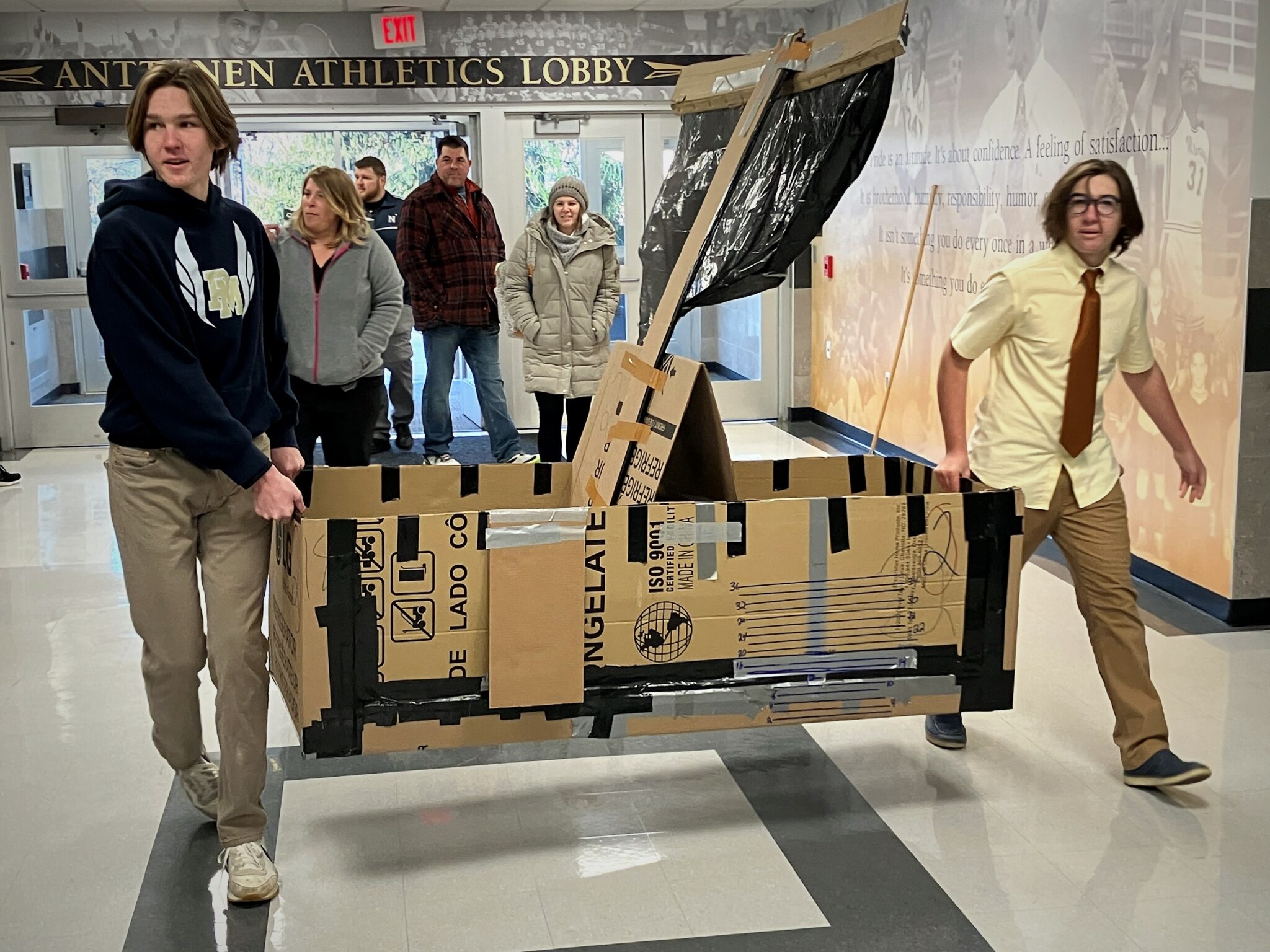 Photo of students bringing boats into the swimming pool building