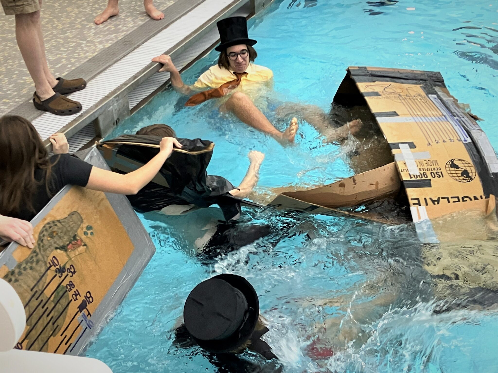 Photo of students in water after falling from carboard boats