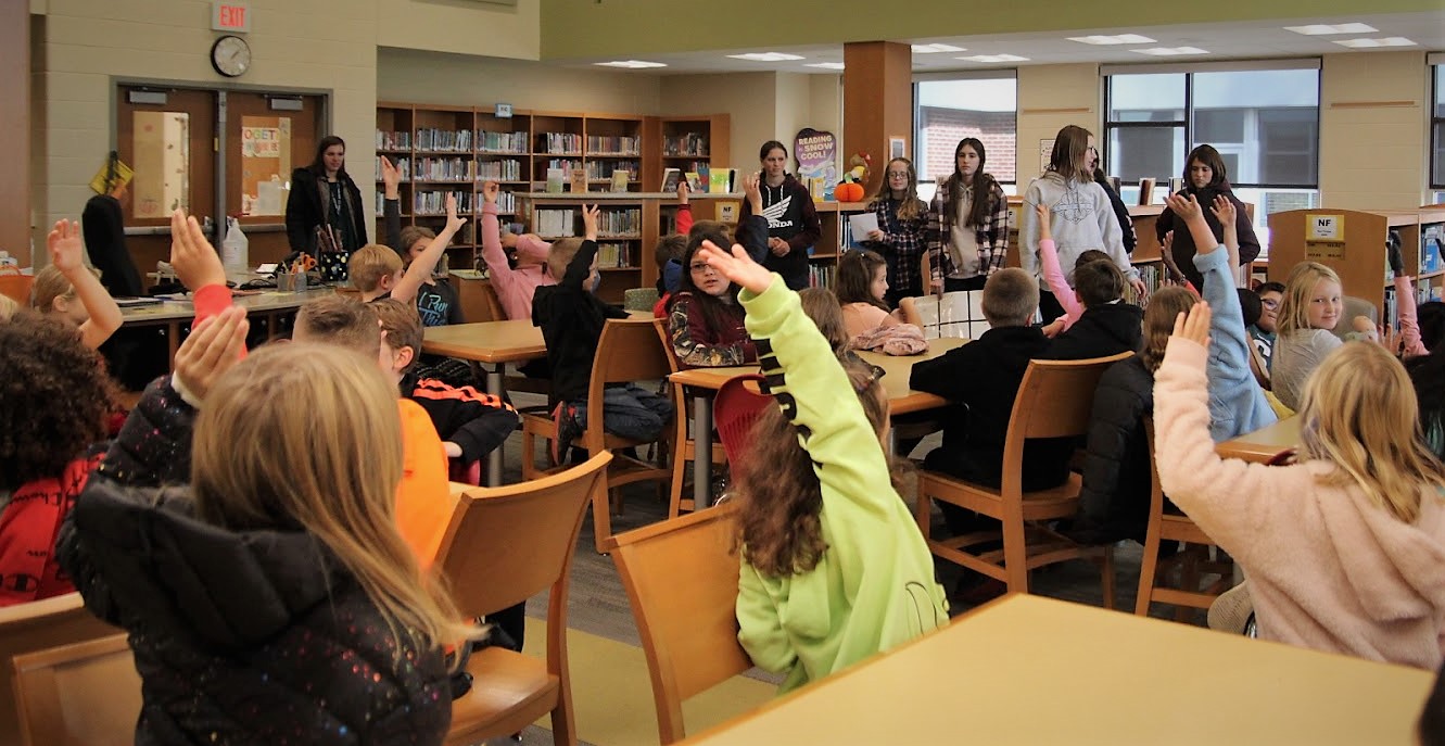 Photo of students presenting information in the library.