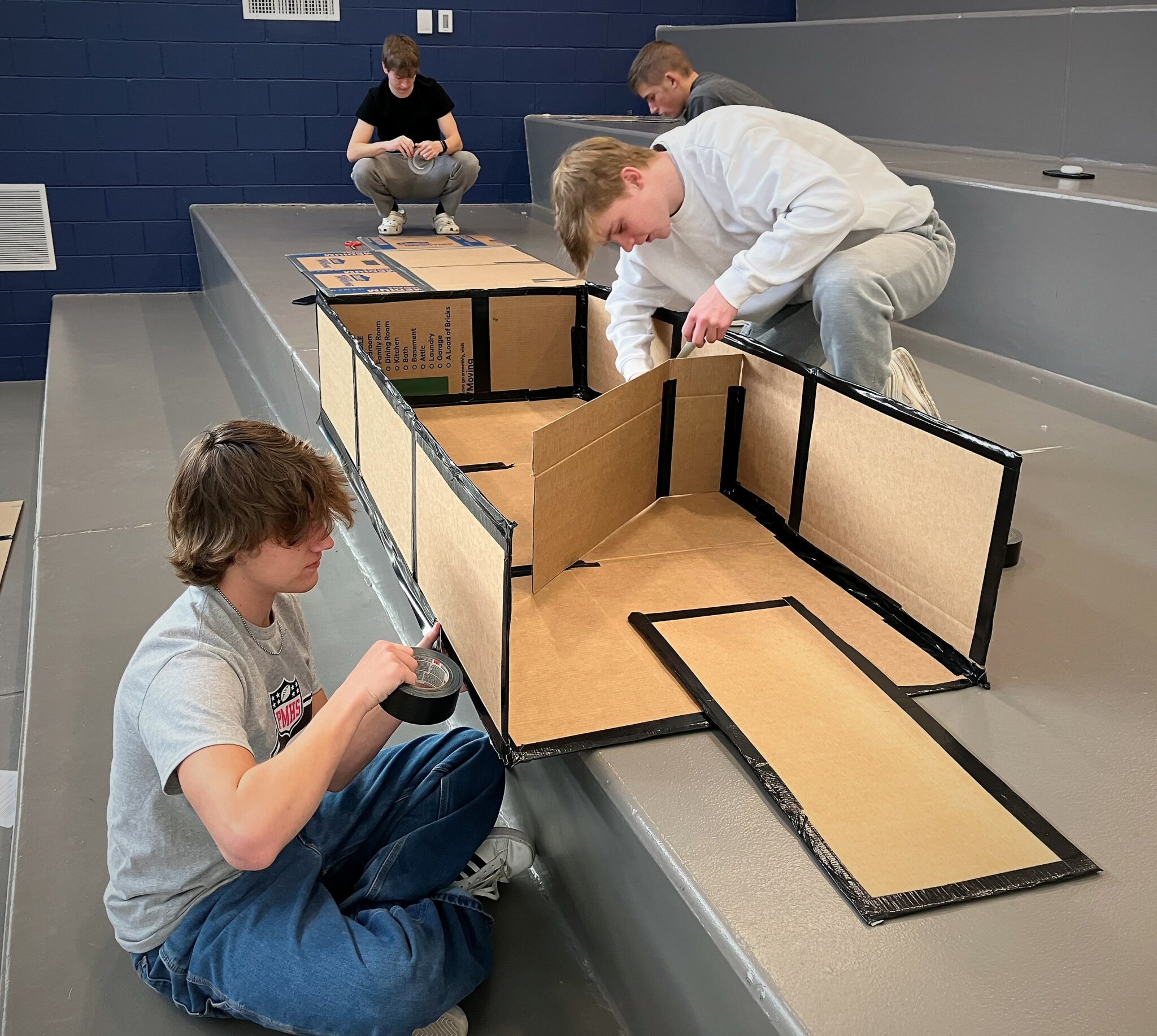 Photo of students building cardboard boats