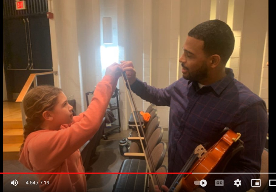 Photo of students and parents learning to play an instrument.