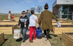 Photo of students and staff carrying soil in buckets