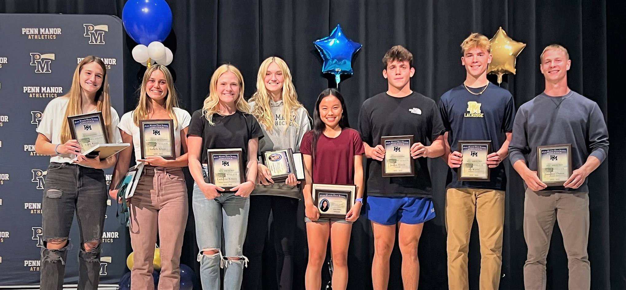 The eight top student athlete award winners posing on stage.