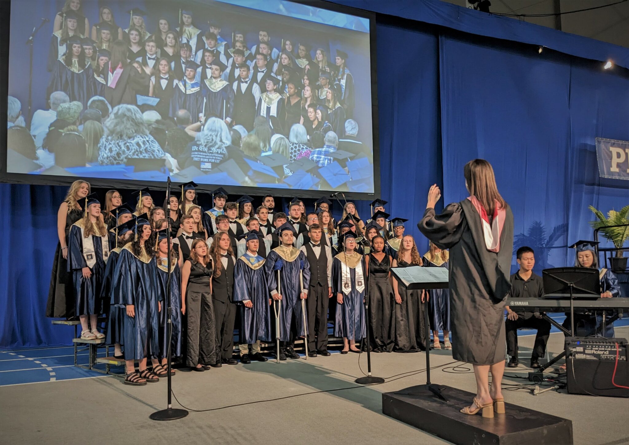 Photo of Manor Singers and choral director singing.