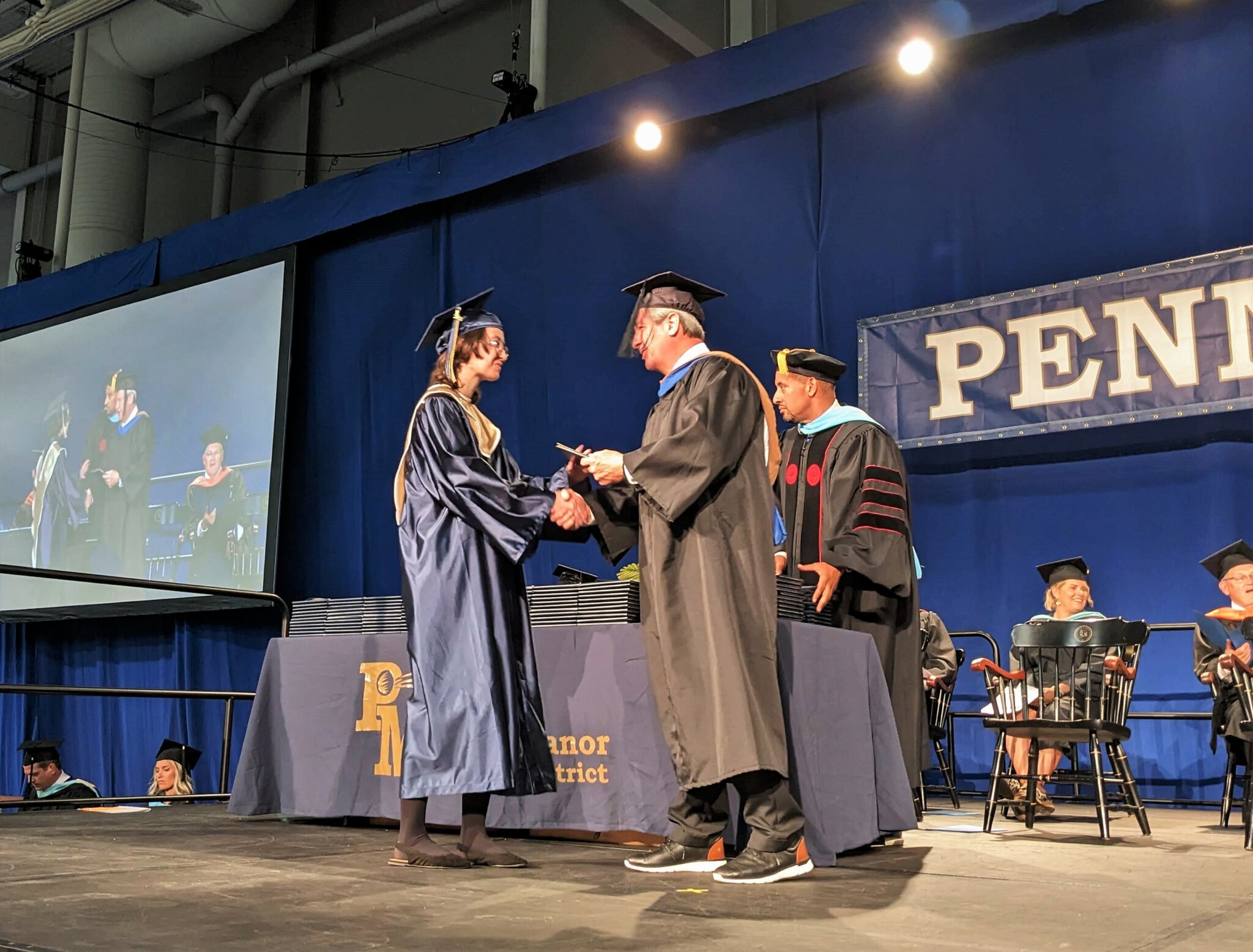 Photo of graduate on stage receiving diploma