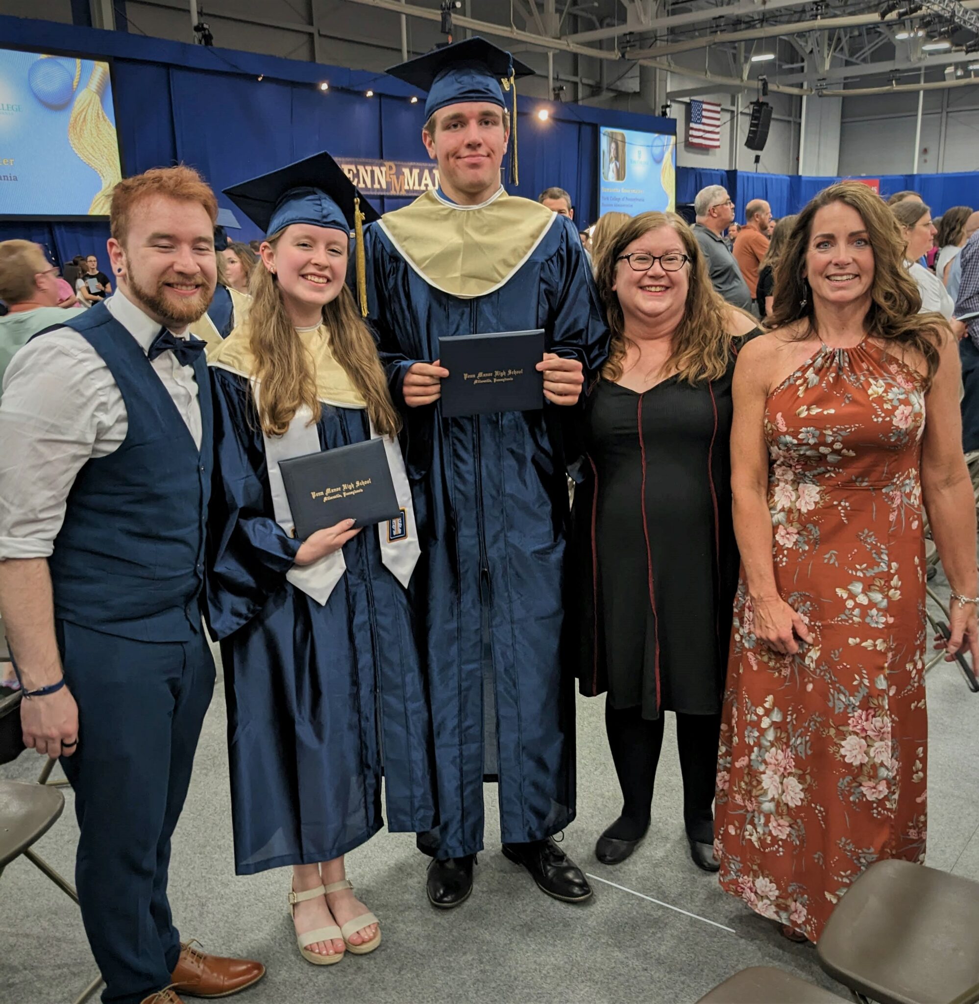 Photo of two graduates with three family member