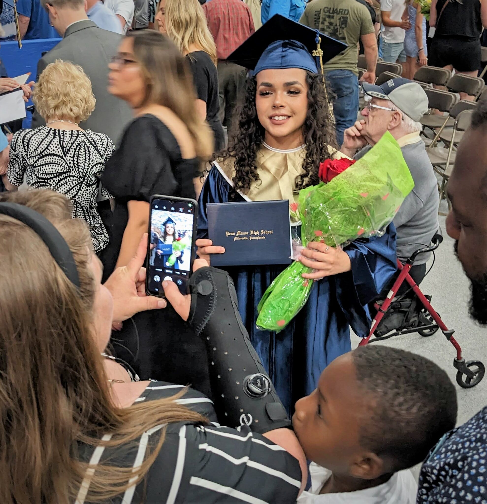 Photo of one graduate holding flowers having her picture taken