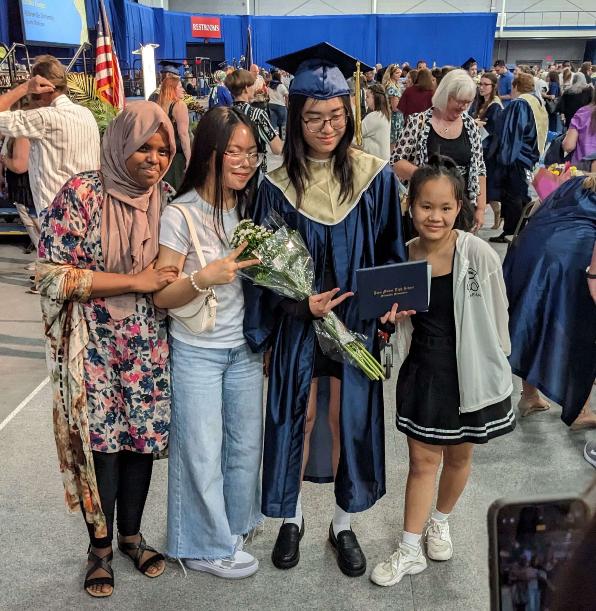 Photo of four people posing with a graduate