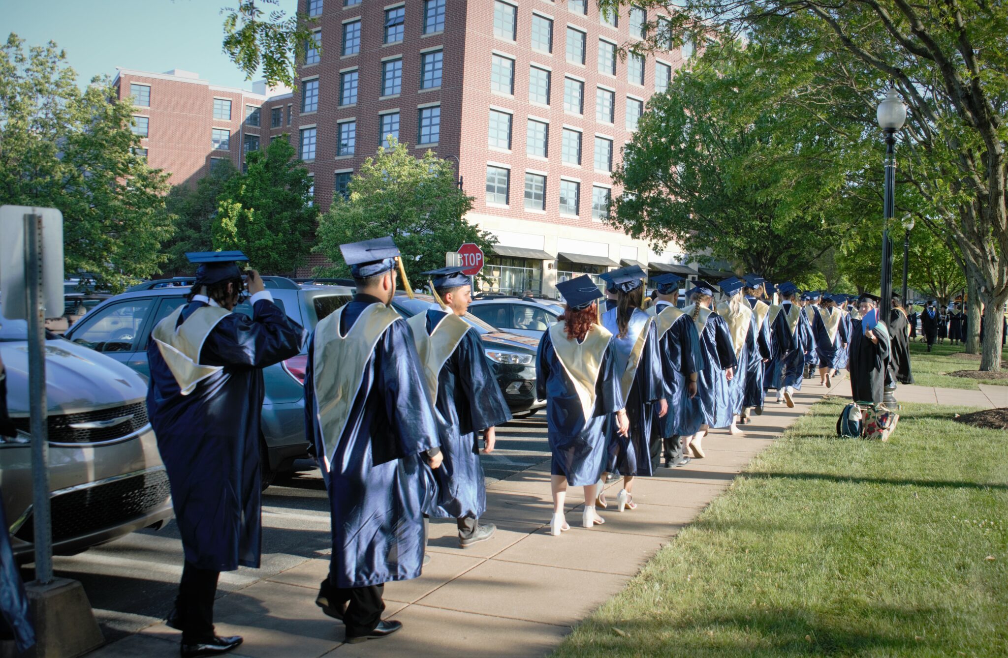 Photo of several dozen graduates lined up outside before the ceremony