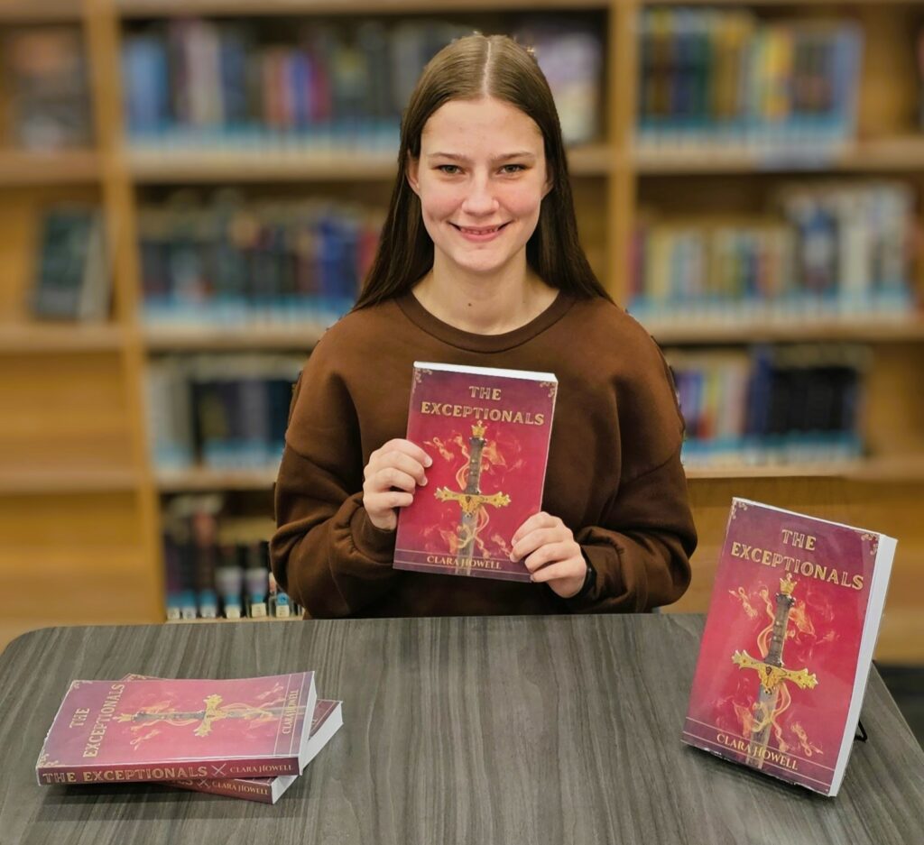 Clara Howell sitting and holding book.