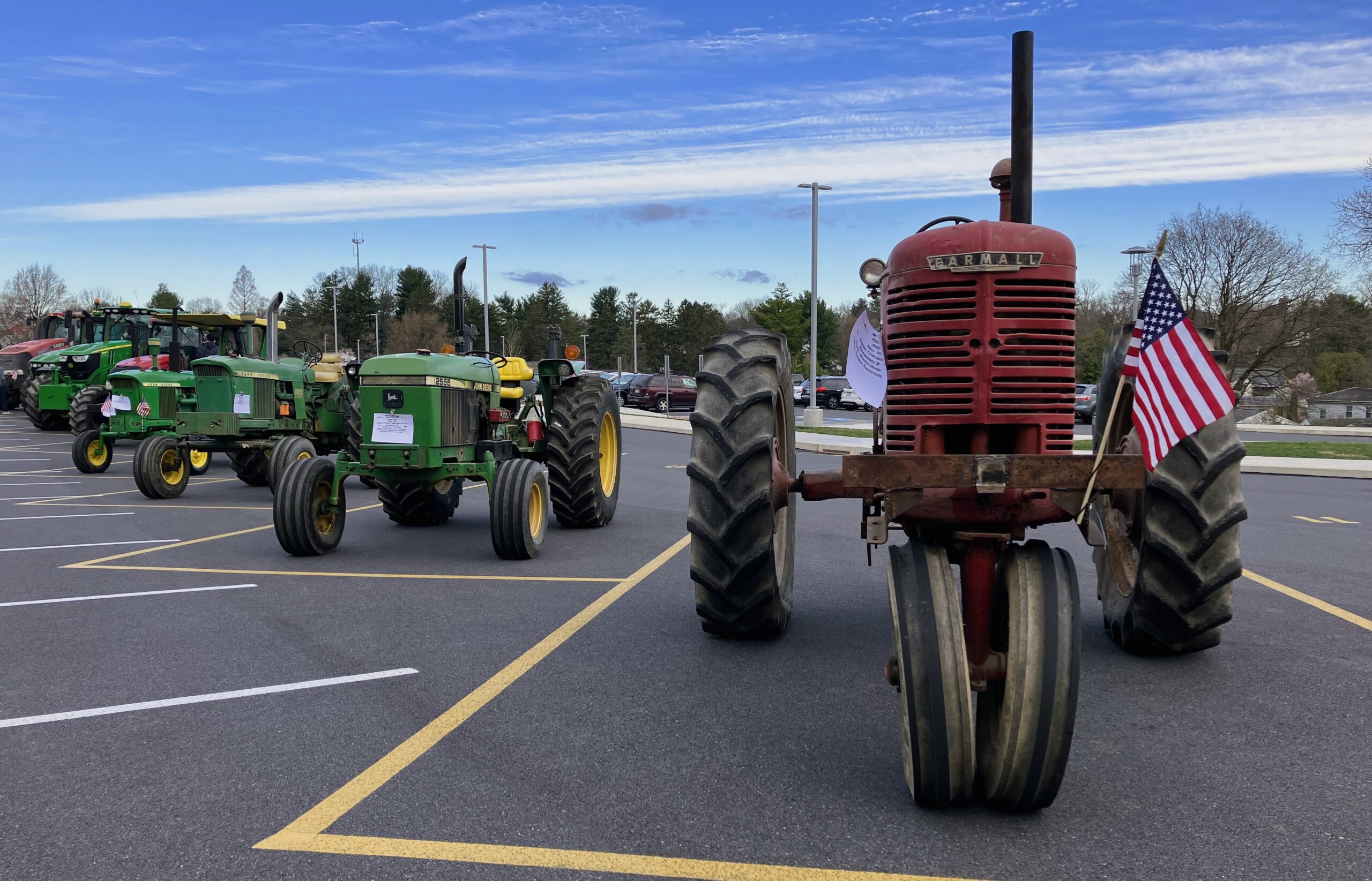 A line of tractors, seen from the front, in the parking lot.