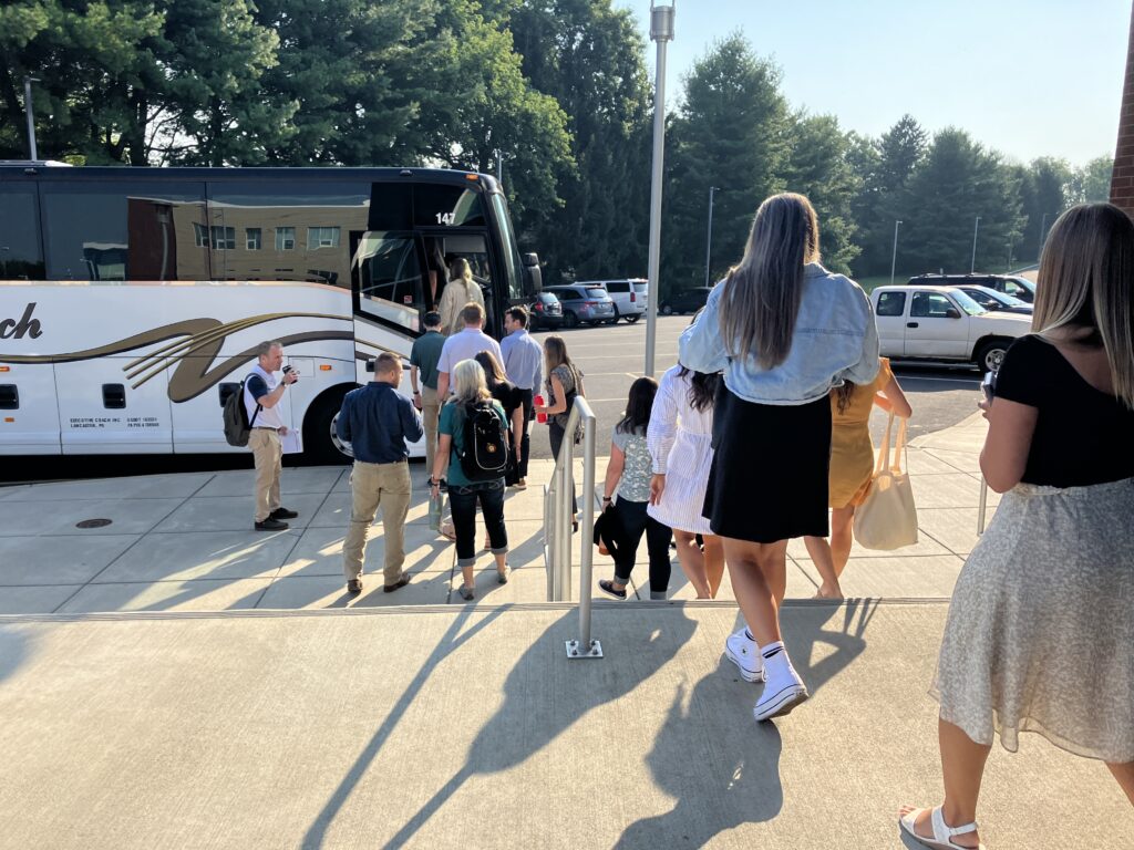 Several teachers boarding a bus.
