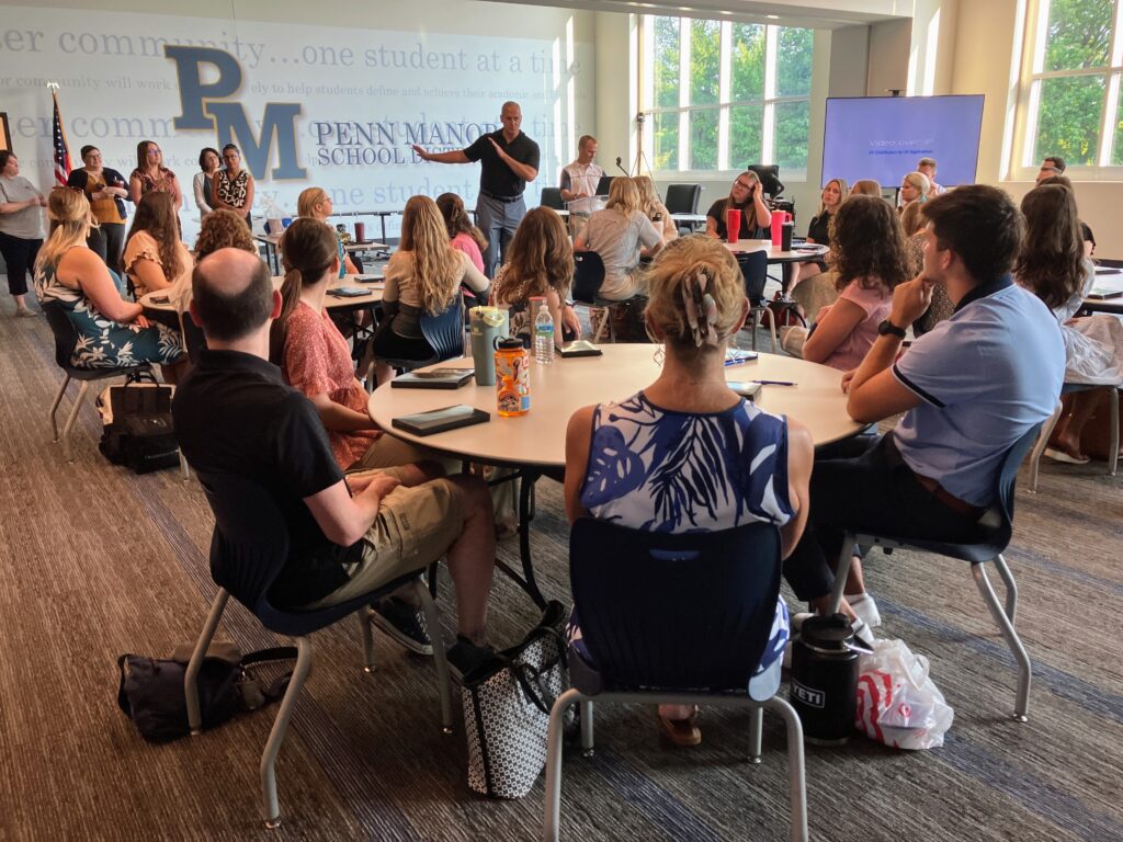 Thirty new teachers listening to superintendent Dr. Phil Gale.