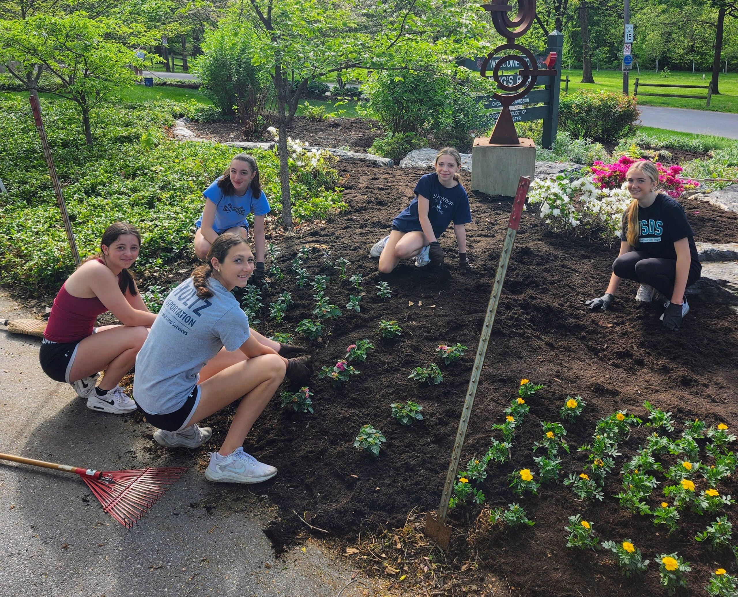 Five students planting flowers at Long's Park