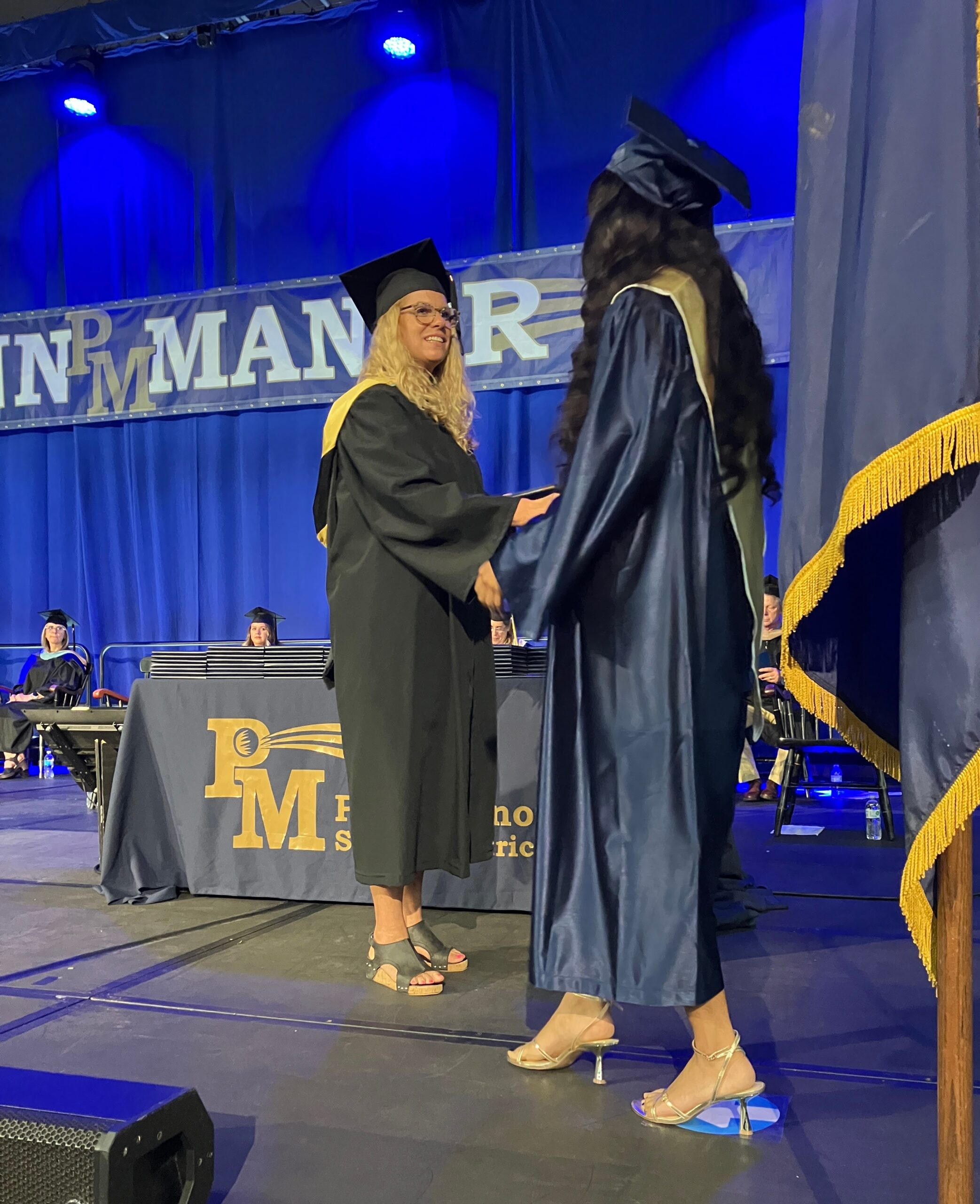 One graduate receives her diploma onstage.