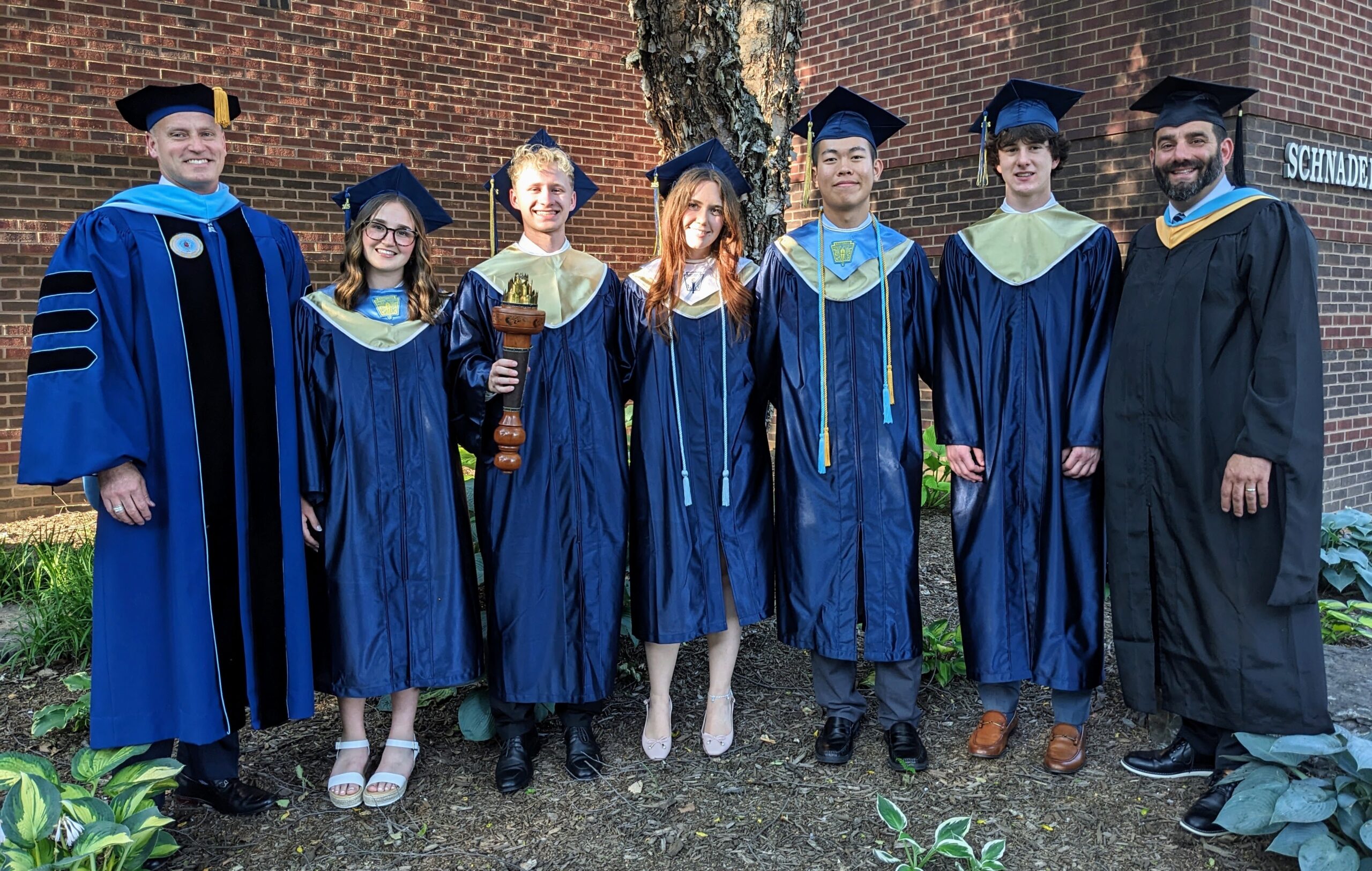 Commencement speakers pose outside with principal and superintendent.